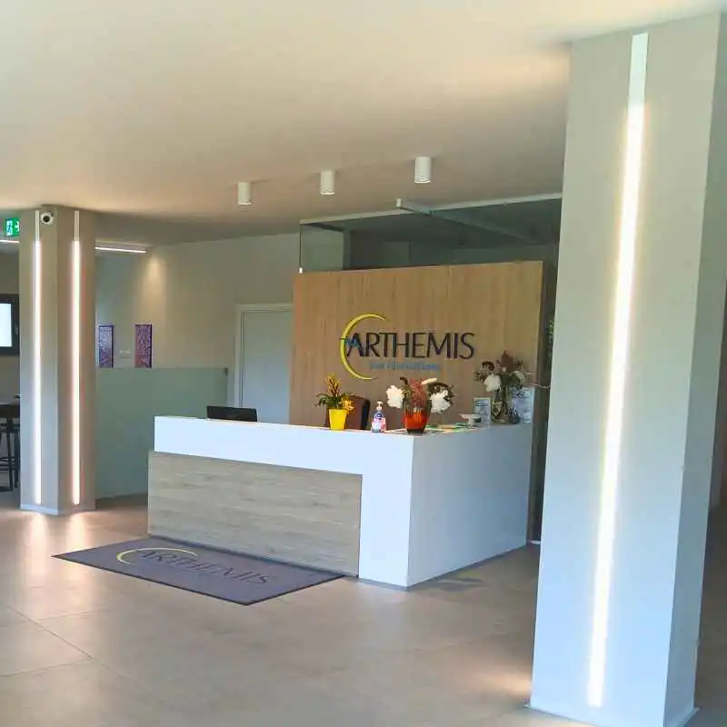 Reception moderna di una casa funeraria con bancone bianco e fiori