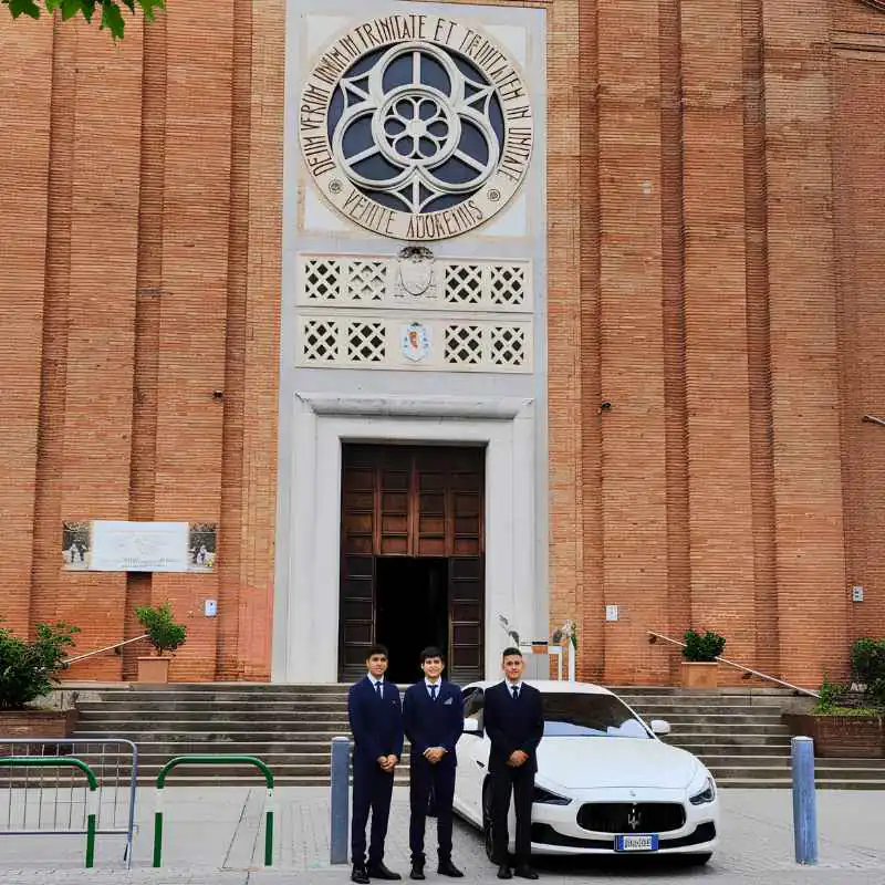 Il personale accanto al carro funebre davanti alla chiesa