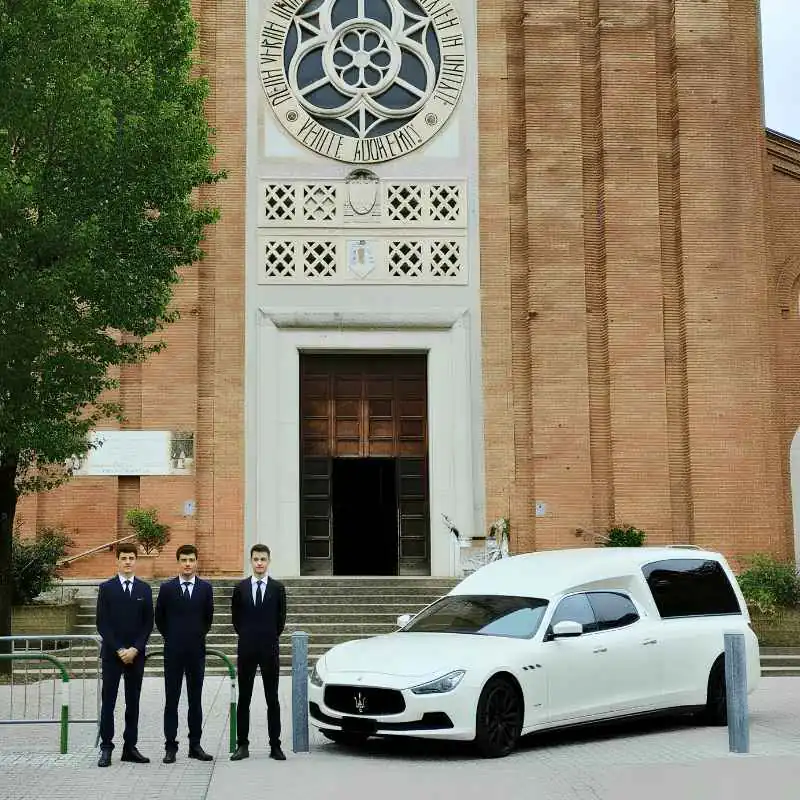 La squadra di Sant'Antonio in abito scuro accanto al carro funebre, davanti alla chiesa