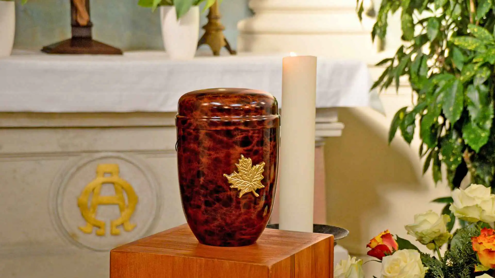 Un'urna cineraria in una sala raccolta, accanto a una composizione di fiori chiari